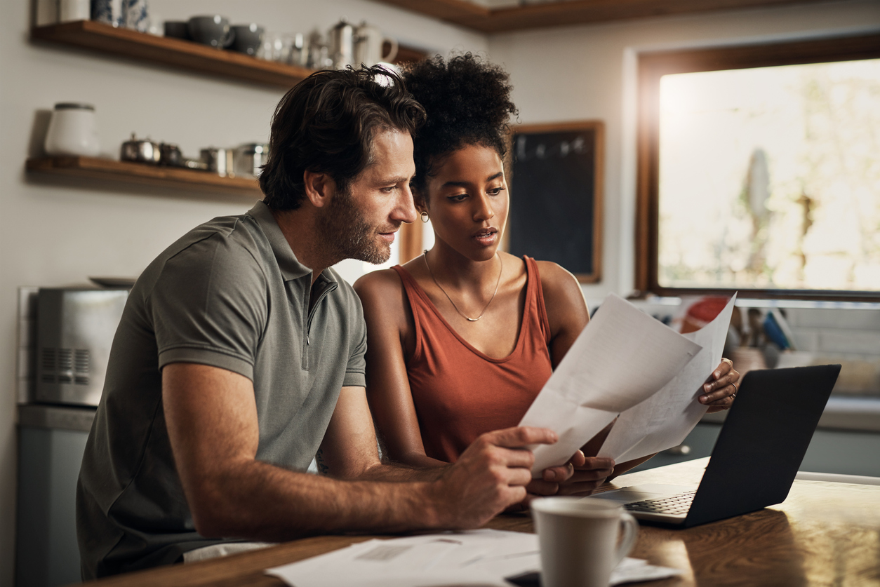 Young couple looking at a Will document in their kitchen