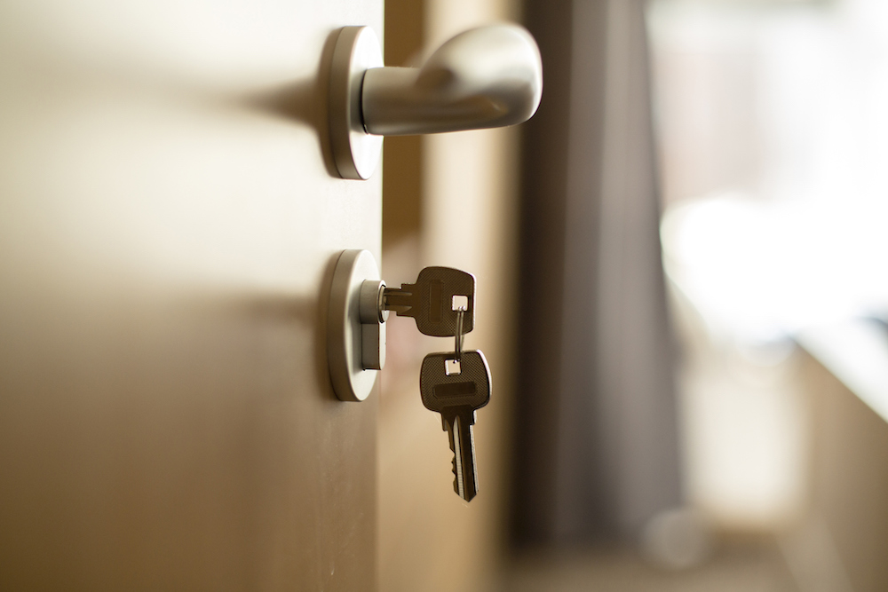 Las llaves de una casa colgando es una cerradura de puerta