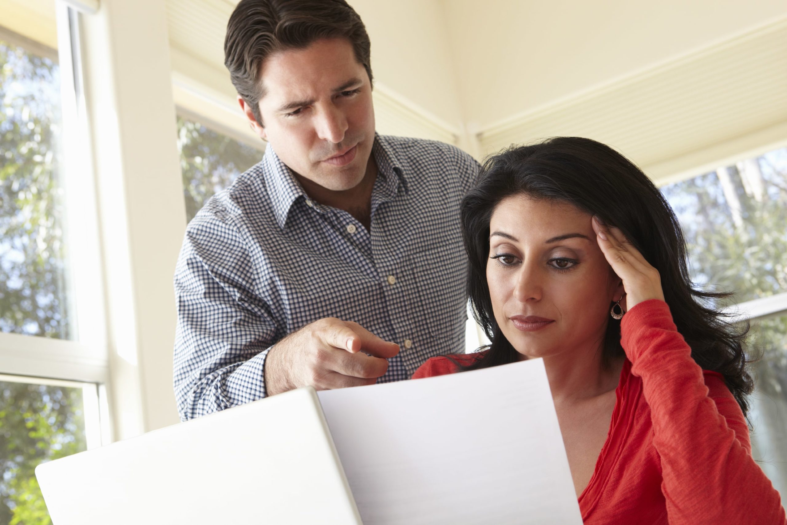 Stressed man and woman landlords looking at a document