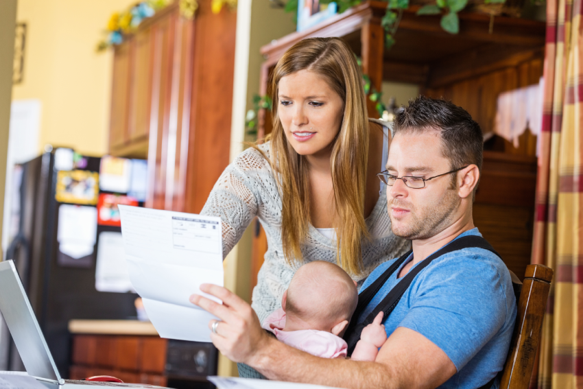Father holding baby and reviewing medical bill