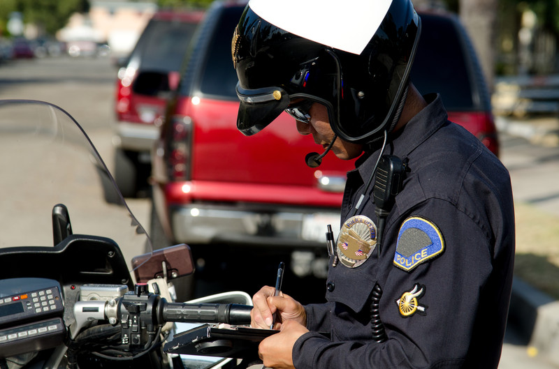 Policeman writing a traffic ticket