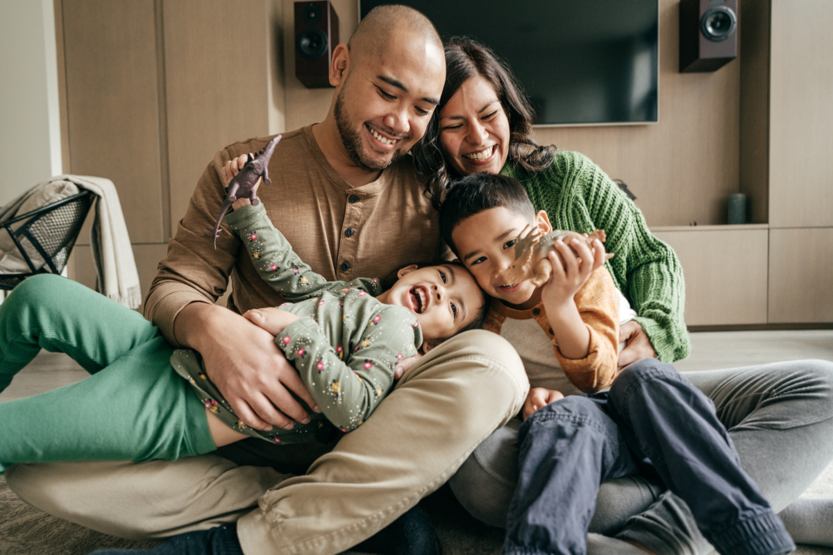 Happy young family playing on couch