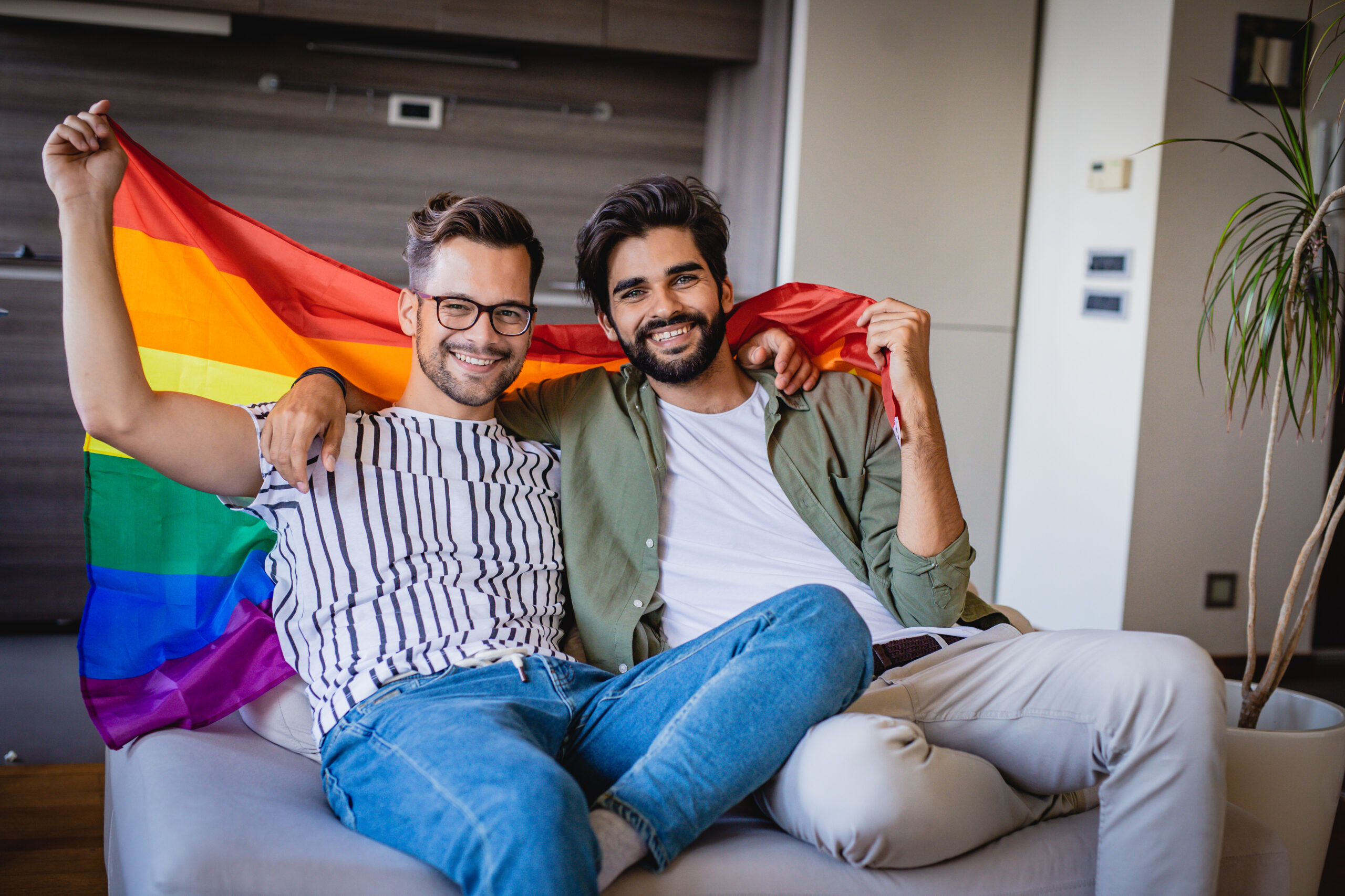 Hombres que sostienen la bandera del arco iris del orgullo gay