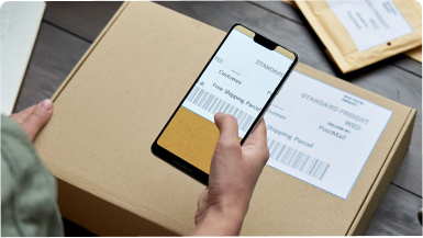 Person using a smartphone to scan a package delivery code.