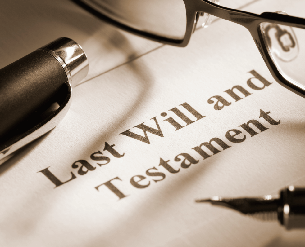 Last Will & Testament laying next to a pair of eyeglasses and an ink pen.