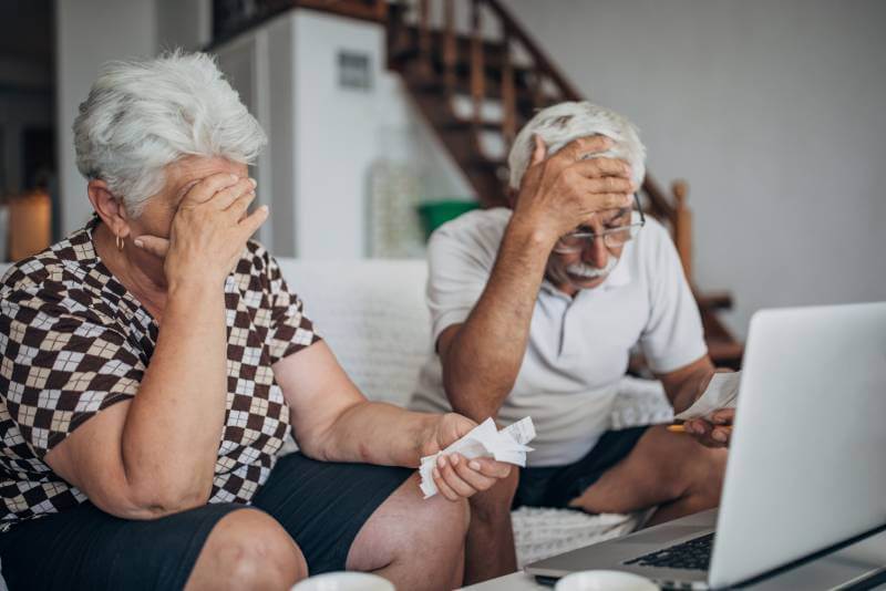 Elderly husband and wife worried after experiencing elderly financial exploitation.